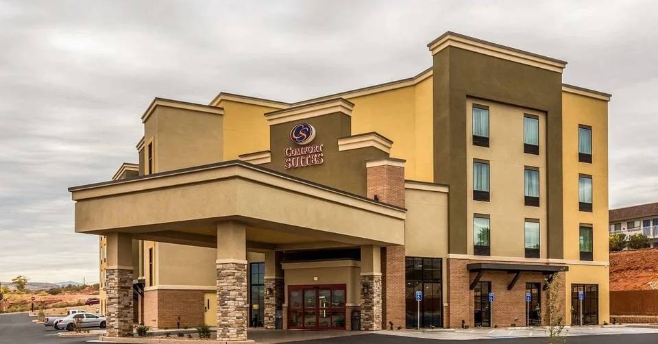 Four-story Comfort Suites building with a covered entrance and stone columns